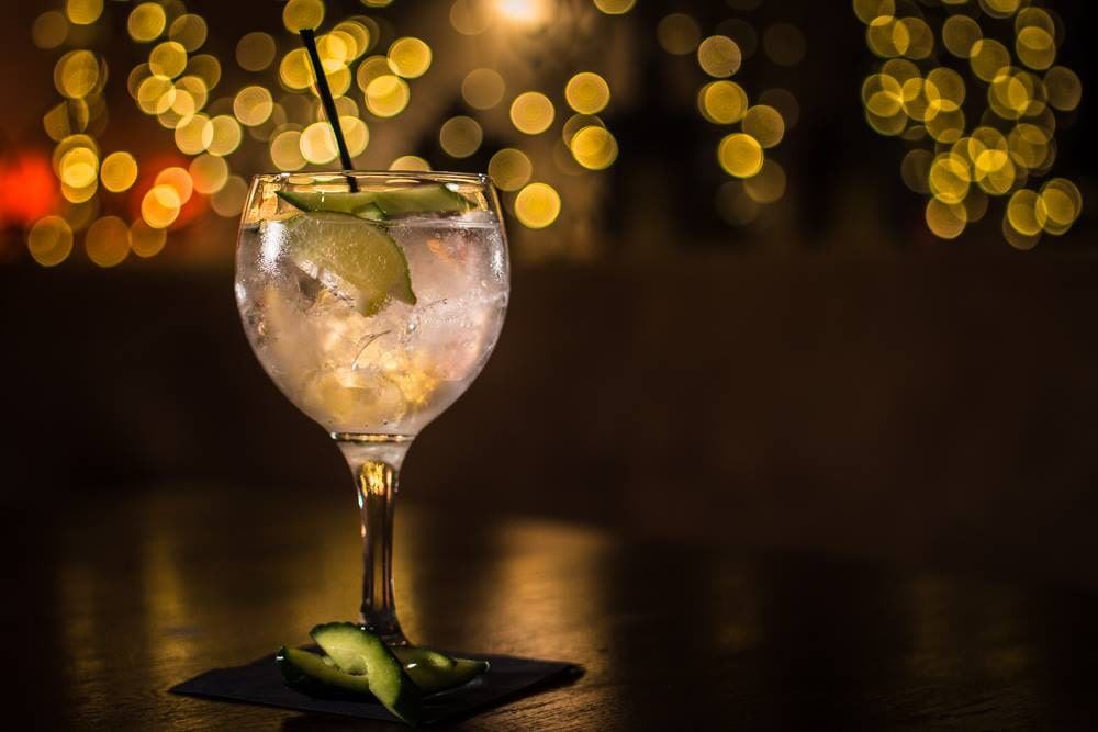 A gin and tonic glowing against fairy lights