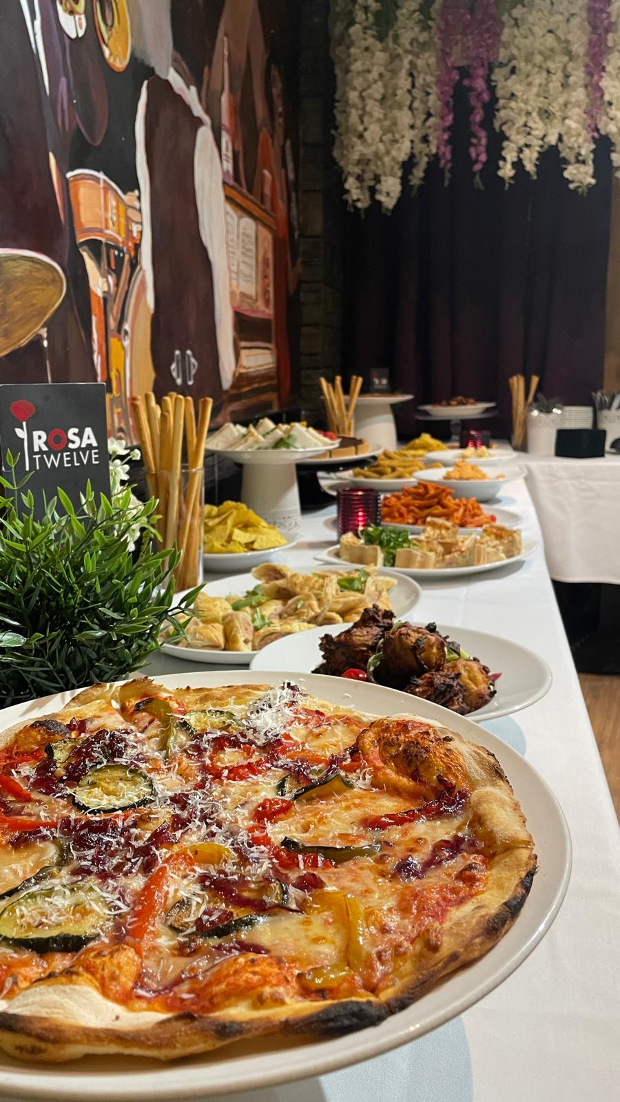 A buffet spread of pizza and sharing dishes at Rosa Twelve